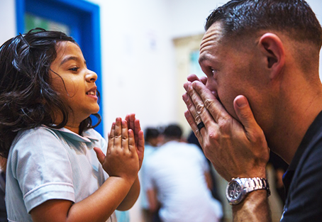 Child and man with hands at face